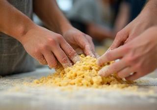 Participants in a cooking class learning to make fresh pasta by hand